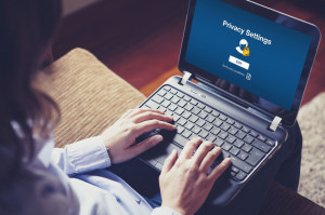"Privacy settings" on the screen. Woman hands over the keyboard