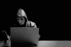 Anonymous computer hacker in white mask and hoodie. Obscured dar