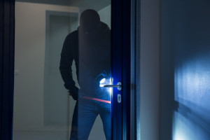 Burglar Using Crowbar To Open Glass Door