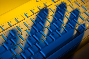 9751580 - computer keyboard and the shadow of a hand. theft of data.